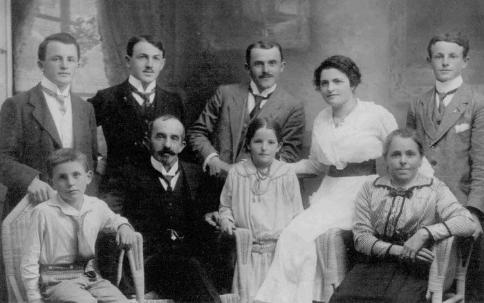 Schwarzweiß-Familienfoto, circa frühes 20. Jahrhundert, neun Personen in formeller Kleidung gruppiert, mehrfach Generationen.